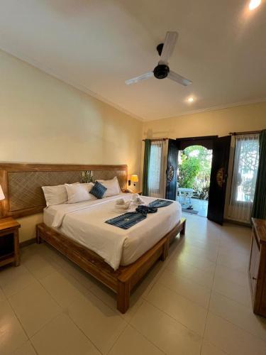 a bedroom with a large bed with a ceiling at Ashyana Candidasa Beach Resort in Candidasa