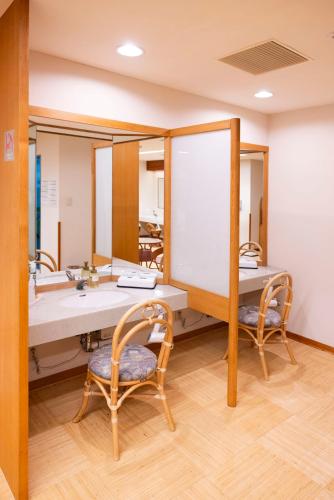 a dressing room with two mirrors and two chairs at Okushiga Kogen Hotel in Yamanouchi