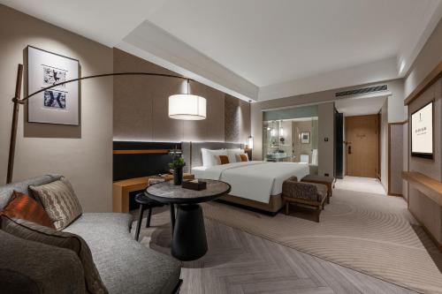 a hotel room with a bed and a table at Rainbird Hotel in Chengdu