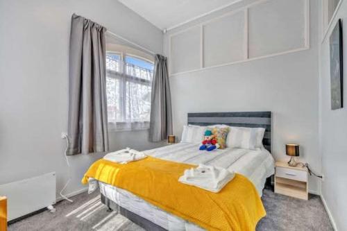 a bedroom with a large bed with a yellow blanket at Ruawai Post Office Accommodation in Ruawai