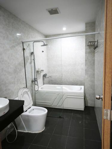 a bathroom with a tub and a toilet and a sink at Kakashi Hotel Phú Quốc in Phú Quốc