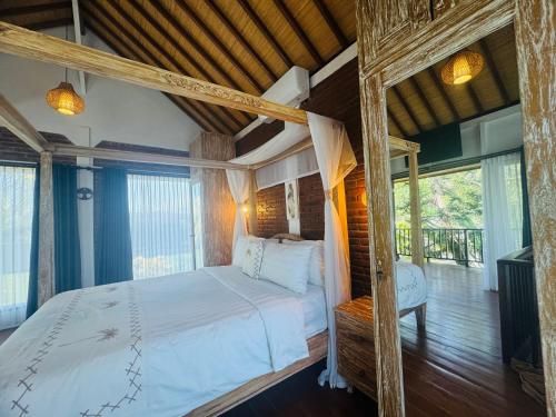 a bedroom with a bed in a room with windows at Sunsets at Sumbul in Pulukan