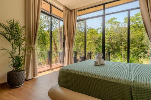a bedroom with a bed and a large window at ArtiZen Hideout near Hin Kong Beach in Hinkong