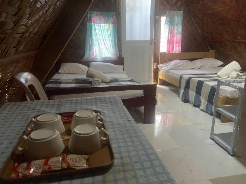 a room with two beds and a tray of food at Sea Breeze Camp in Siquijor