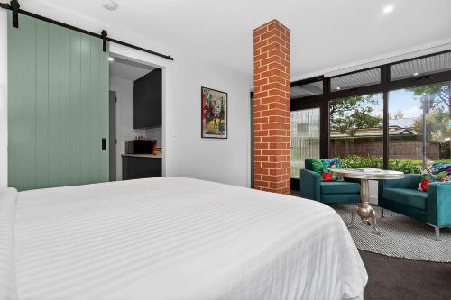 a bedroom with a bed and two chairs and a table at Dulwich Studio in Rose Park