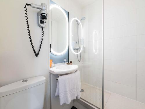 a white bathroom with a sink and a mirror at ibis Chalon Sur Saone Nord in Chalon-sur-Saône