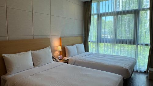 a hotel room with two beds and a window at Hotel Icc in Daejeon