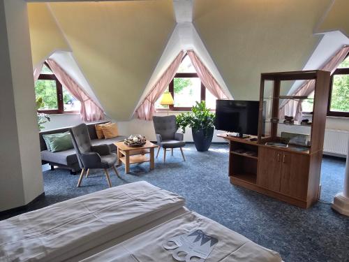 a bedroom with a bed and a tv in a room at Hotel Waldesruh in Lengefeld