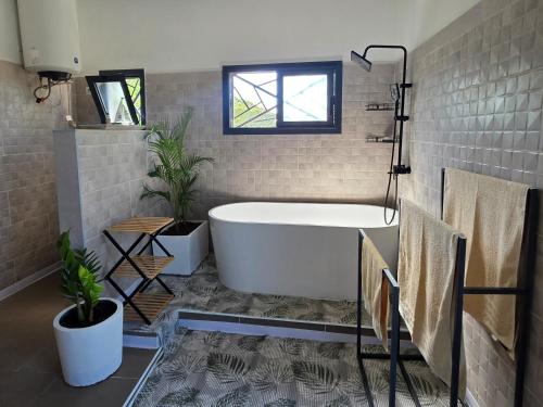 a bath tub in a bathroom with a tile floor at Villa Tsara Nosy be in Nosy Be