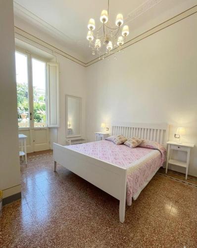 a bedroom with a large bed and a chandelier at Le Cascine in Pisa