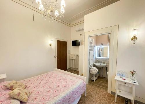 a bedroom with a pink bed and a bathroom at Le Cascine in Pisa