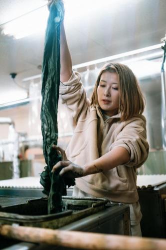 a young girl standing in a kitchen preparing food at B&B Hachi in Kyoto