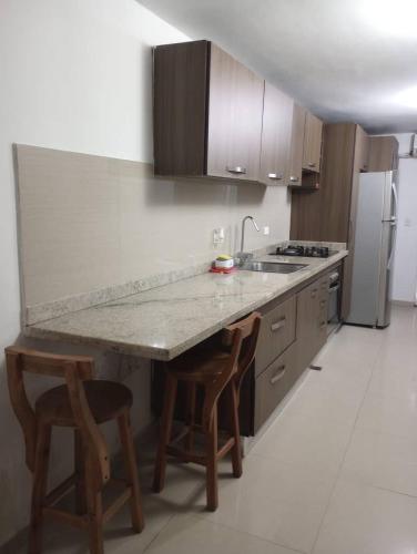 a kitchen with a marble counter top and wooden cabinets at Apartamento lechería in El Morto de Barcelona