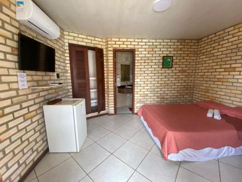 a room with a bed in a brick wall at Pousada Chalés do Cunhaú in Canguaretama