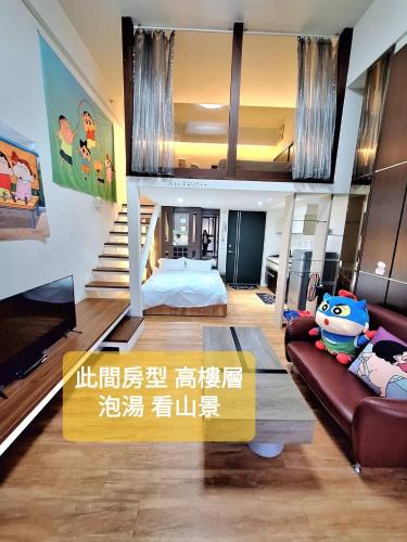 a living room with a bed and a couch at Capybara樓中樓湯屋 in Jiaoxi