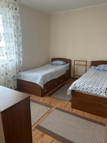 two beds in a room with two rugs at Lovely House in Cholpon-Ata