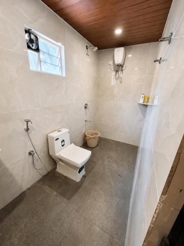 a bathroom with a toilet and a window at Mayura sea view in Malpe