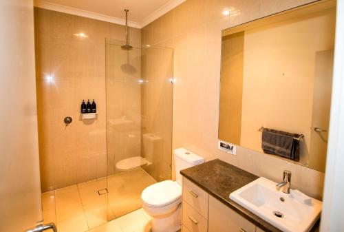 a bathroom with a shower and a toilet and a sink at Flinders Rest in Queenscliff