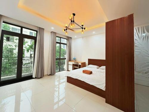 a bedroom with a bed and large windows at LV TPHomes in Ho Chi Minh City