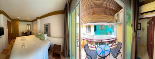 a room with a table and chairs and a window at Aura Hotel Phi Phi in Phi Phi Islands