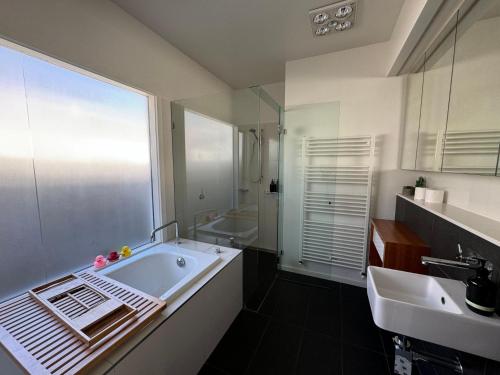 a bathroom with a tub and a sink at Galway Cottage in Queenscliff