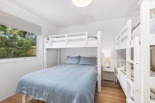 a bedroom with two bunk beds and a window at Lochaber in Point Lonsdale