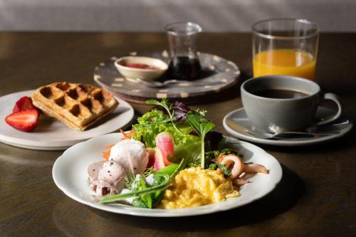 a table with two plates of food and a cup of coffee at CAFE & BB guri in Ine