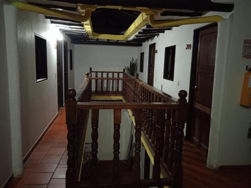 a hallway with a wooden staircase in a house at Hotel Casona de San Pedro in Curití
