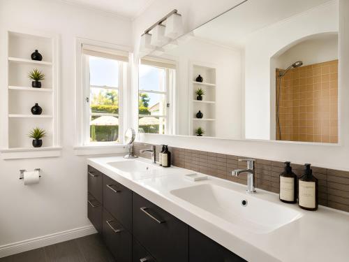 a bathroom with two sinks and a large mirror at Gloria Palm Springs in Palm Springs