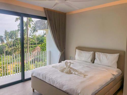 a bed with a bow on it in a bedroom at Luxury Villa Infinity Pool Panoramic Seaview Villa Ananda in Ban Thung