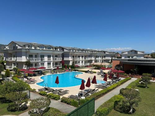a view of a resort with a pool and chairs and umbrellas at Defne Beach Makri in Fethiye