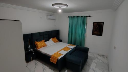 a bedroom with a bed and a green curtain at Sweet Inn Limbe in Limbe