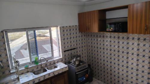 a kitchen with a sink and a window at Sweet Inn Limbe in Limbe