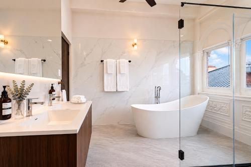 a white bathroom with a tub and a sink at Hotel Magnolia Boutique in Panama City