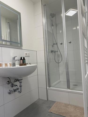 a white bathroom with a sink and a shower at Blue Stay 2 in Bremen