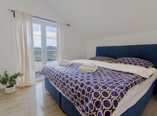 a bedroom with a blue and white bed with a window at Villa Marija Zaton in Dubrovnik