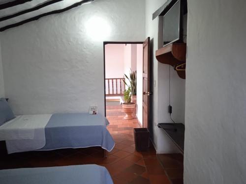 a bedroom with a bed and a door to a balcony at Hotel Casona de San Pedro in Curití