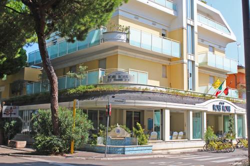 um edifício amarelo com uma varanda em cima em Hotel Royal em Misano Adriatico