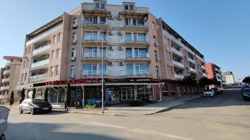 a tall building on a street with a car parked in front at Апартамент 310 in Primorsko