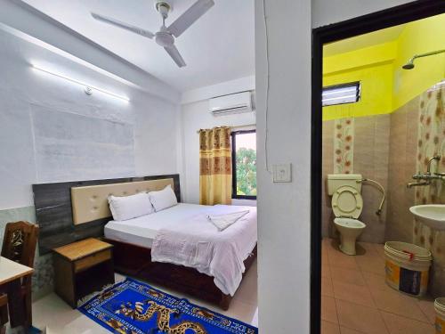 a bedroom with a bed and a bathroom with a sink at Lumbini Garden Lodge in Rummindei