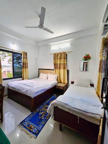 a bedroom with two beds and a window at Lumbini Garden Lodge in Rummindei