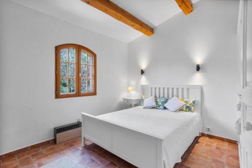 a white bedroom with a bed and a window at Modern Holiday Home Pool & Wifi in Roquebrune-sur-Argens