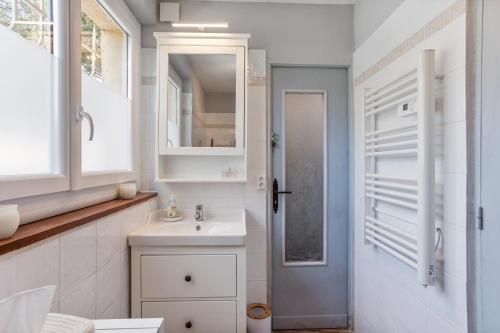 a white bathroom with a sink and a mirror at Modern Holiday Home Pool & Wifi in Roquebrune-sur-Argens