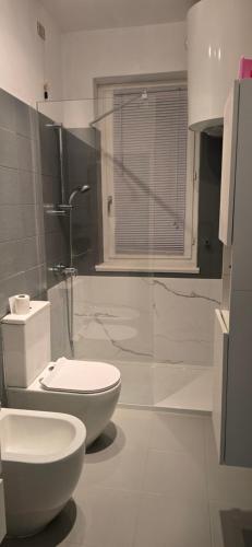 a white bathroom with a toilet and a shower at La Casetta al Lago in Sorico