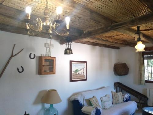 a living room with a chandelier and a couch at El Garrotal in El Bosque