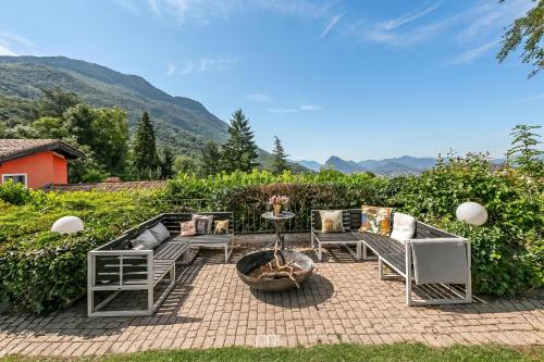 a patio with chairs and a table and a fire pit at Villa Tre Pini Garden Escape in Lugano