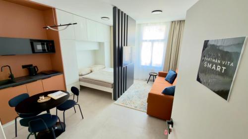 a living room with a couch and a table and chairs at Apartmán Vita Smart in Trenčín