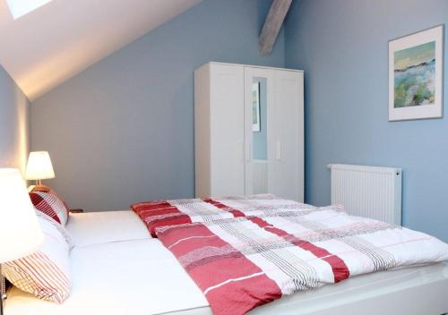 a bed with a red and white blanket on it at 6-Personen-Fewo in Buchholz