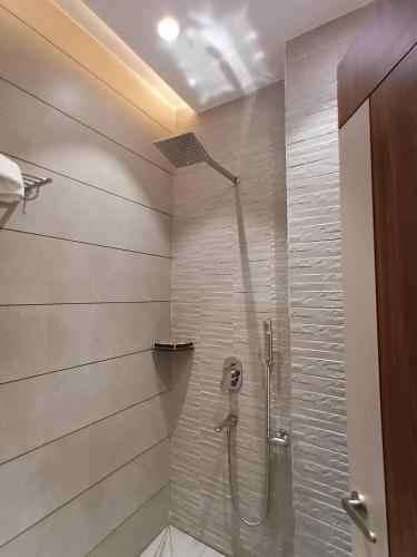 a bathroom with a shower with a glass door at Hotel Shrivardhan in Sūratgarh