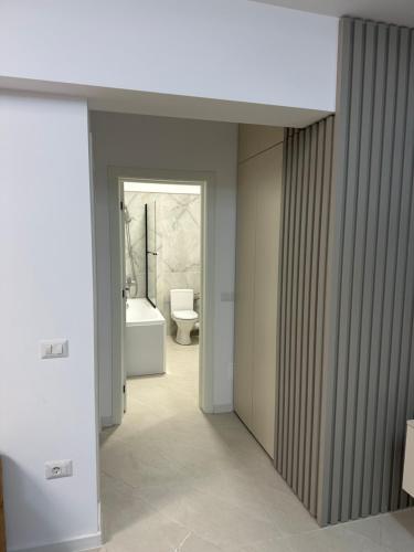 a hallway with a bathroom with a toilet and a sink at Apartament Magnolia Panoramic in Craiova